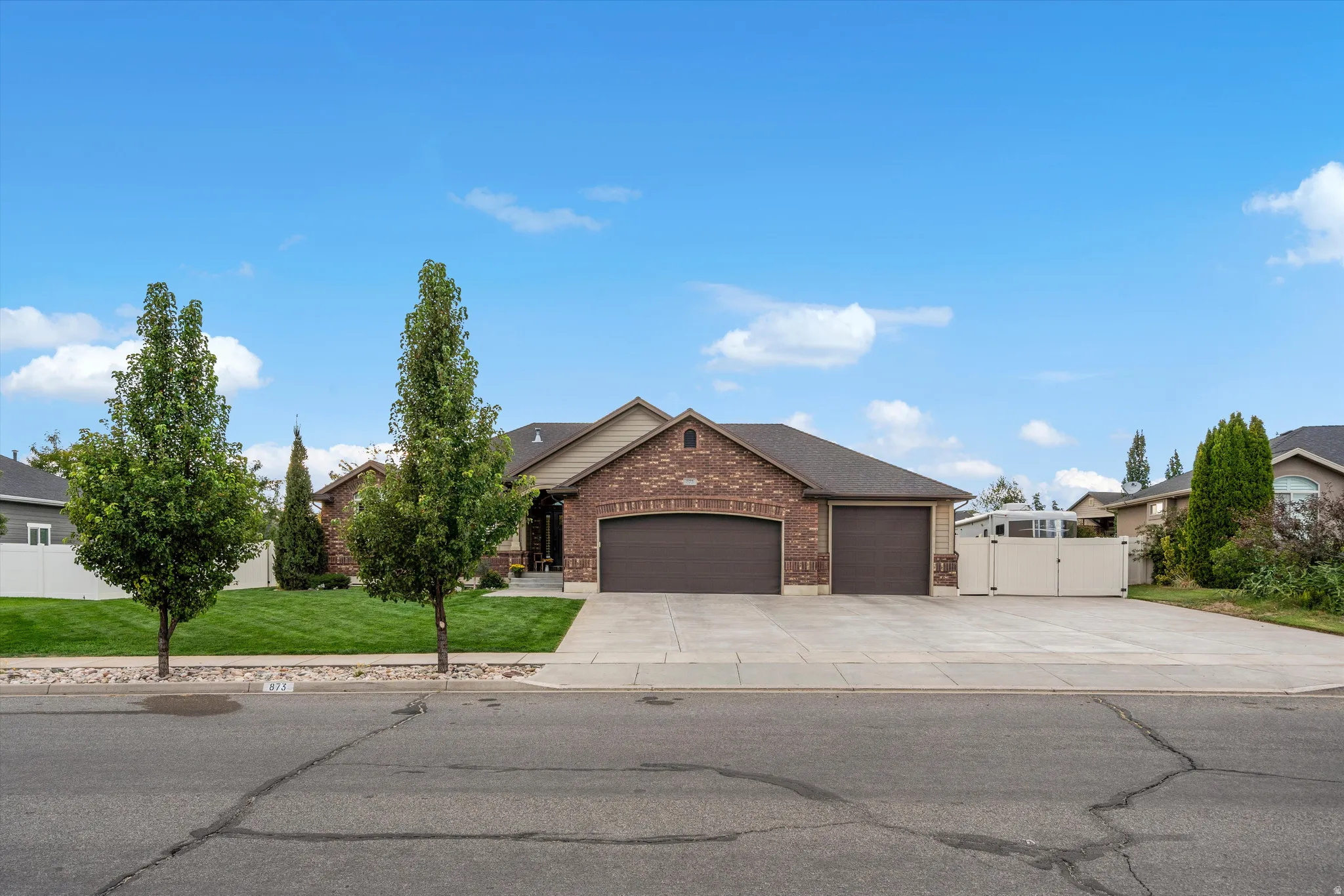 Brick exterior with a multi-car garage and extended concrete driveway