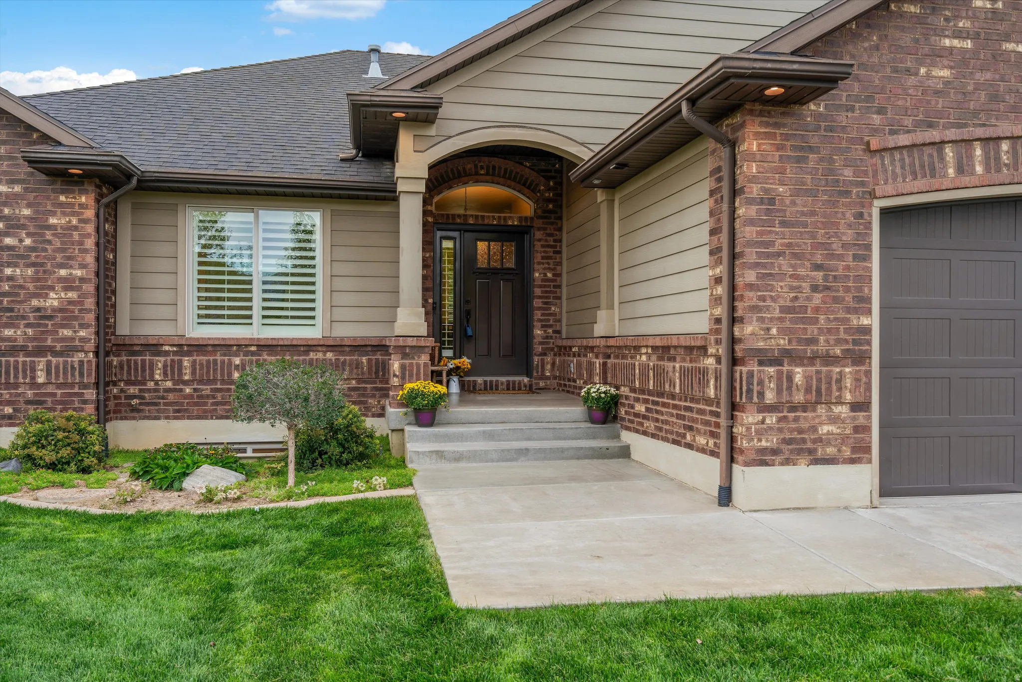 Brick and siding exterior with a dark brown garage door