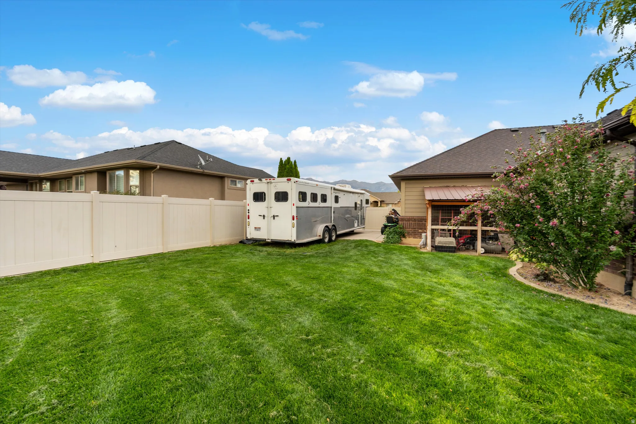 Expansive green lawn with a privacy fence