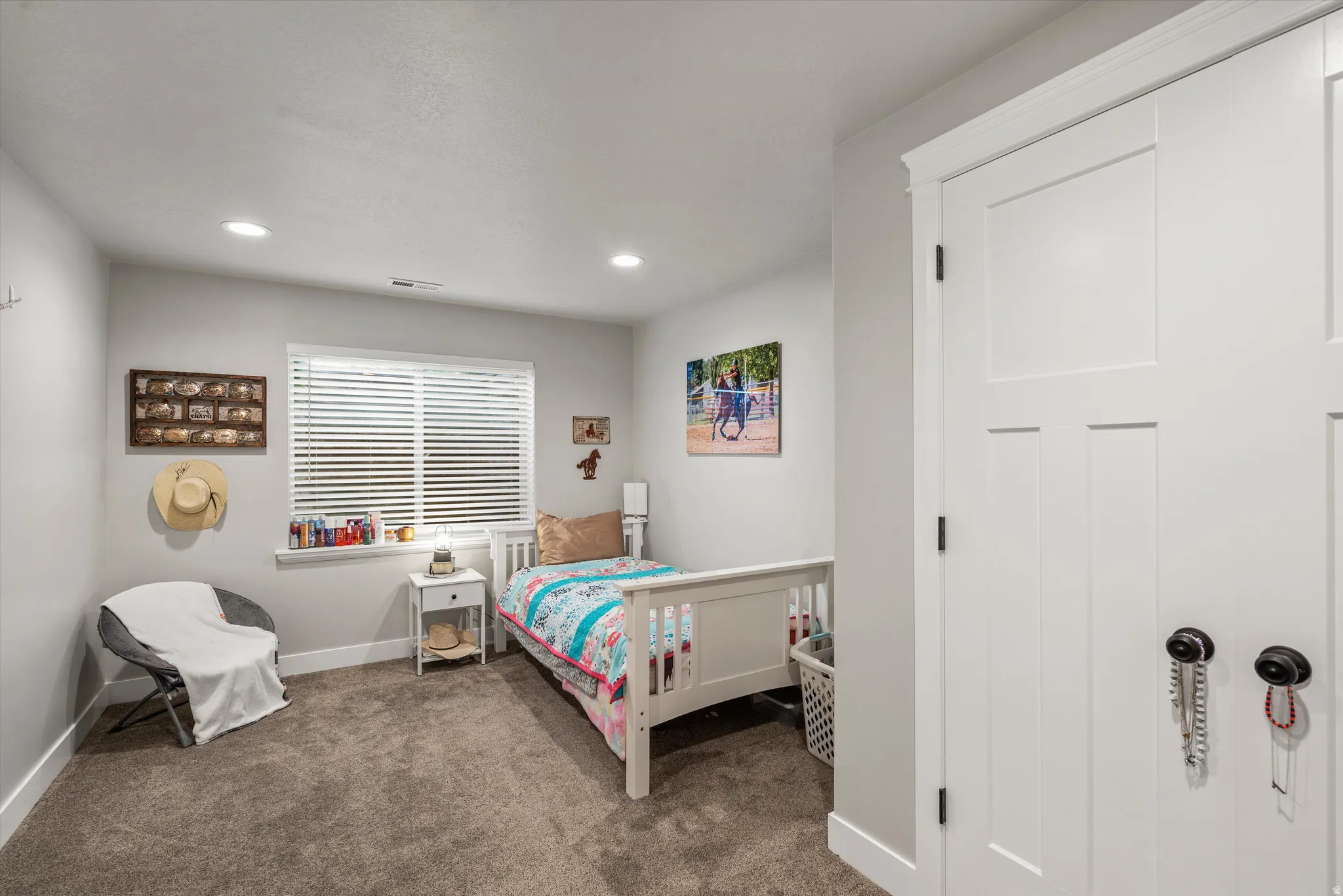 Recessed lighting, window with horizontal blinds, neutral-toned wall paint, and plush carpeting