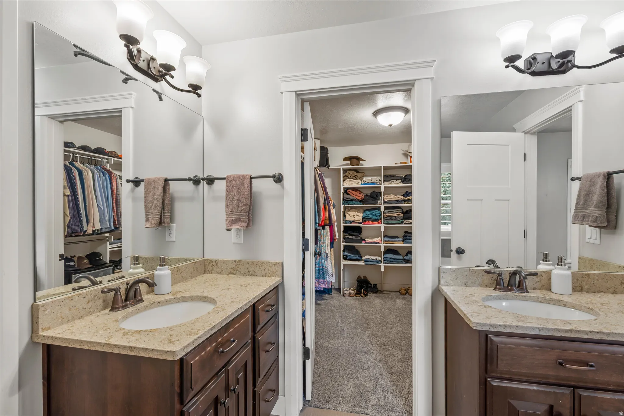 Dual vanities with undermount sinks and light-toned countertops