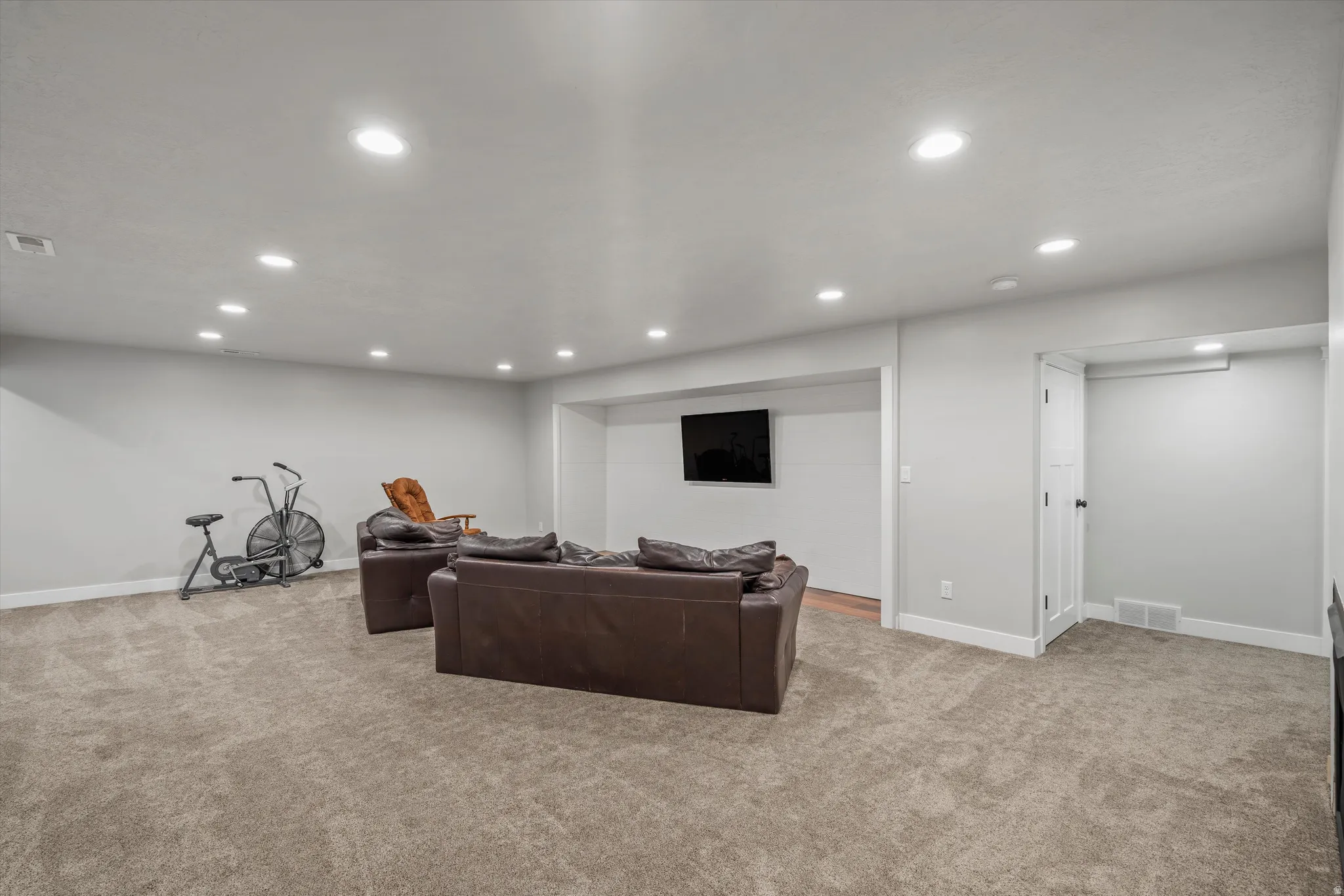 Recessed lighting, light gray walls, carpet flooring, wood-finish flooring, and white trim
