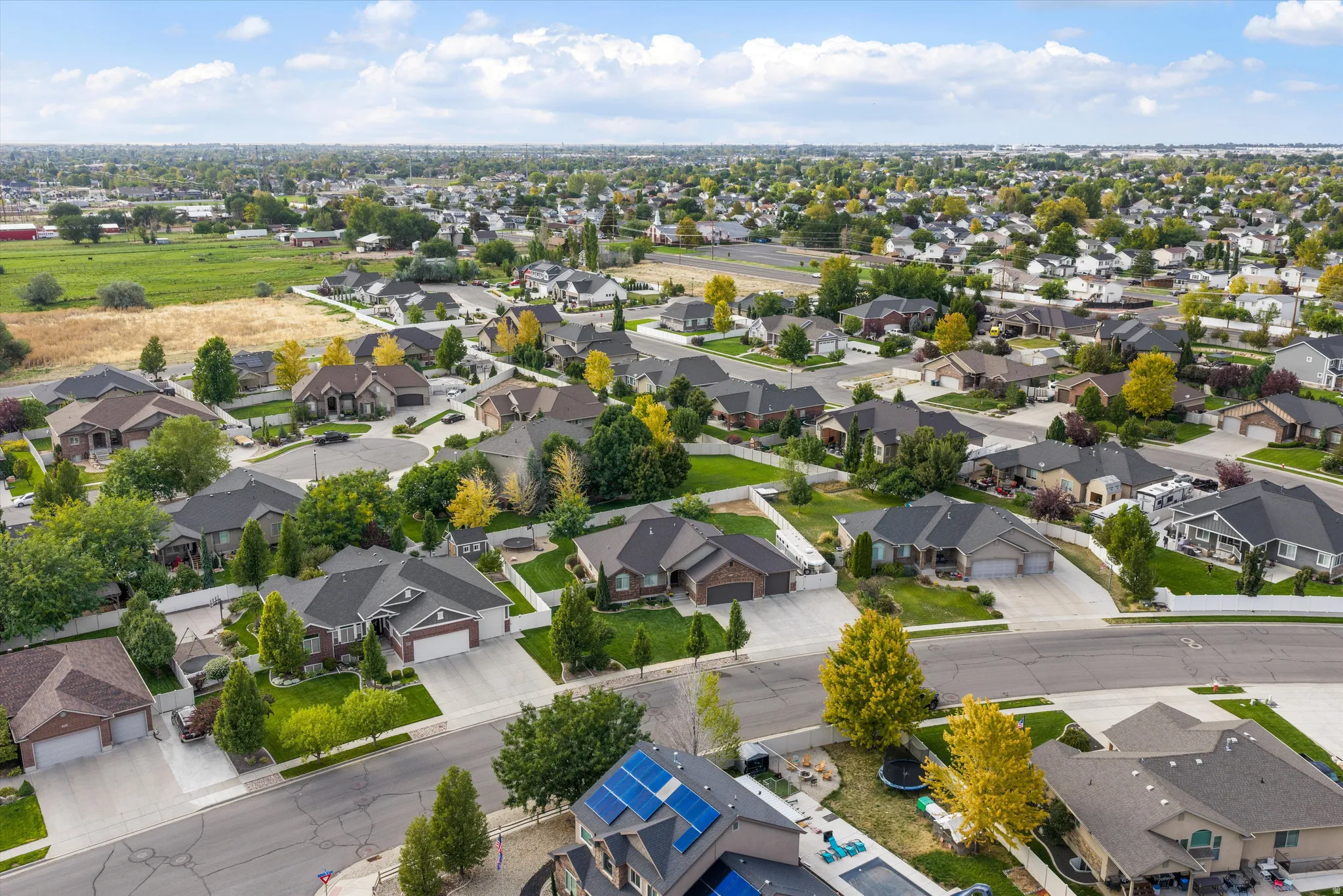 Suburban neighborhood with mature landscaping, paved streets, and a mix of single-story and two-story residences