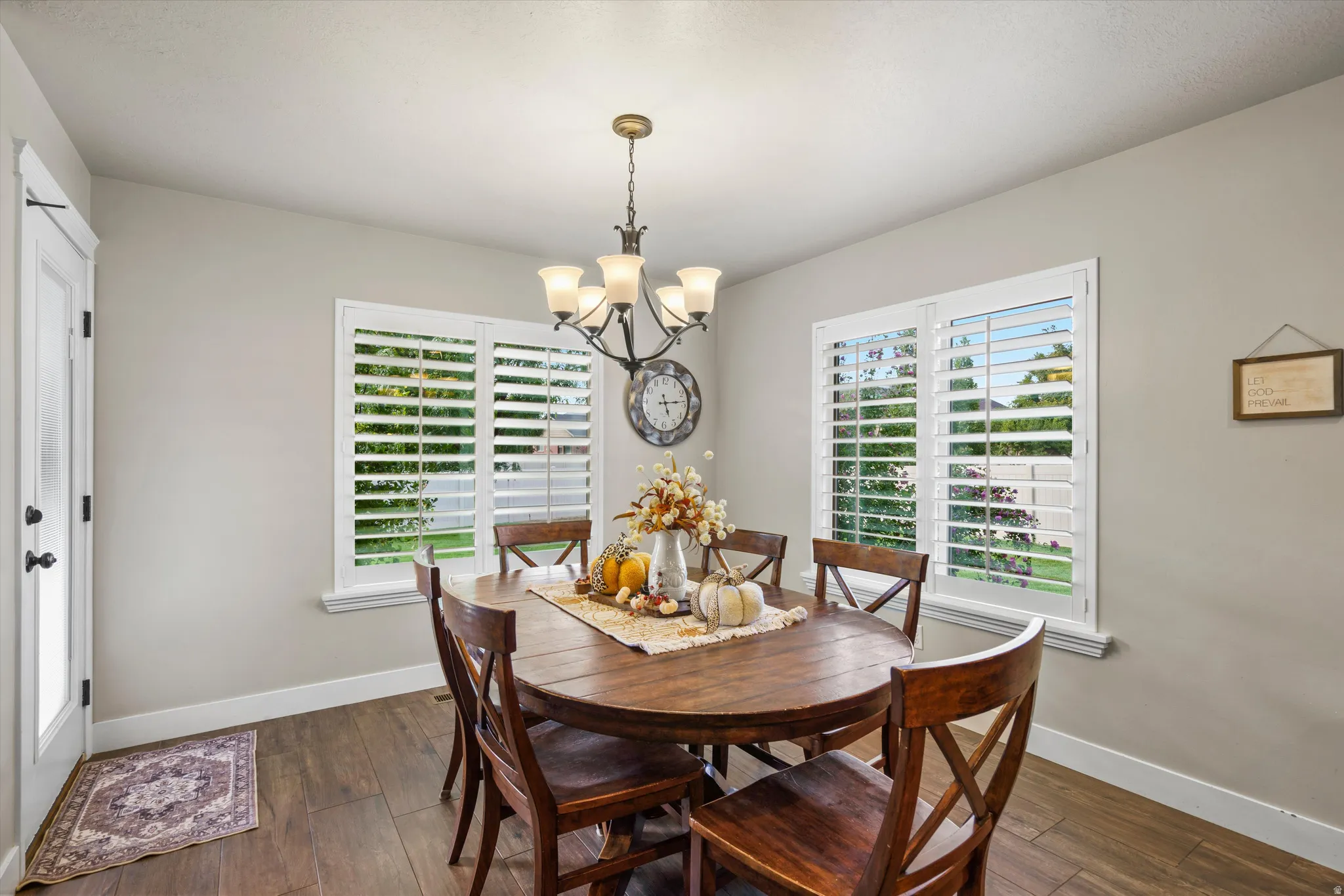 Recessed lighting, wood-finish flooring, white trim, and a classic chandelier