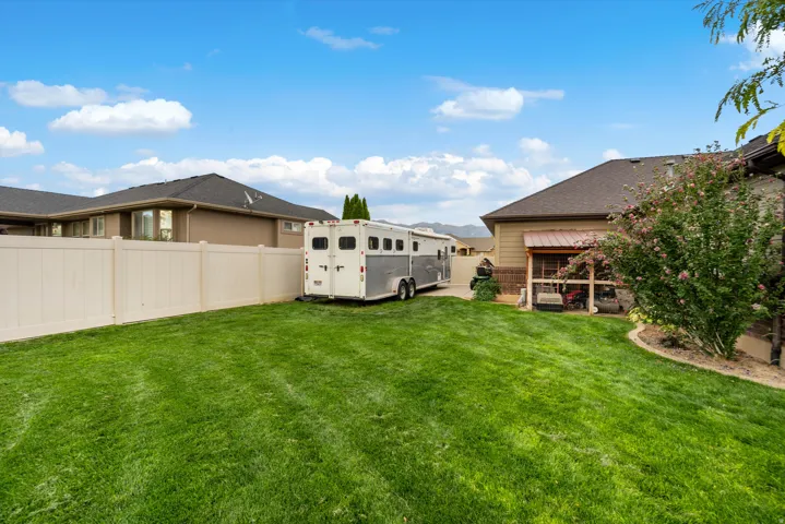Expansive green lawn with a privacy fence