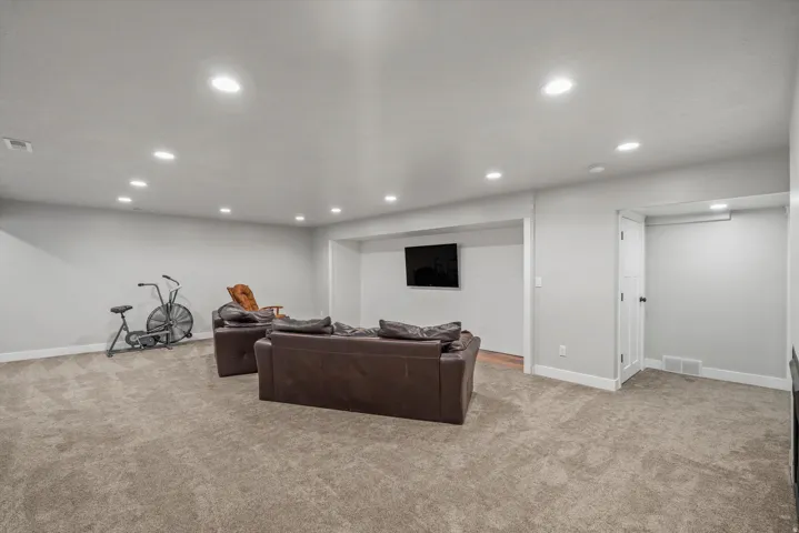 Recessed lighting, light gray walls, carpet flooring, wood-finish flooring, and white trim