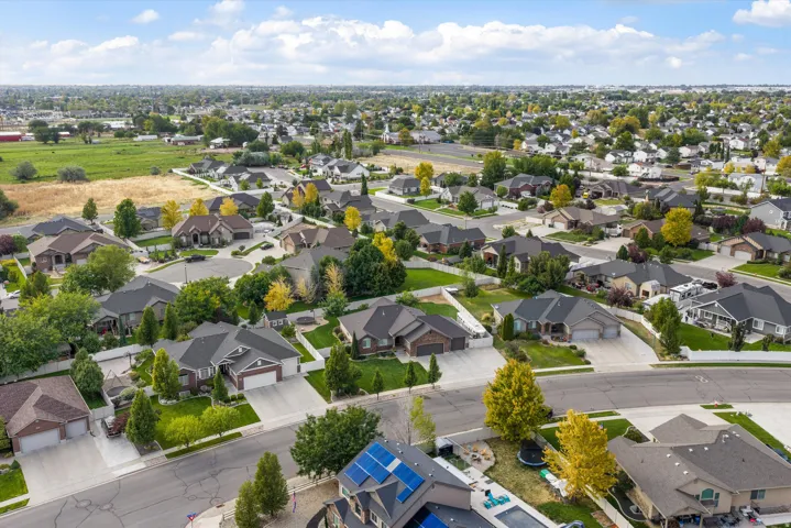 Suburban neighborhood with mature landscaping, paved streets, and a mix of single-story and two-story residences
