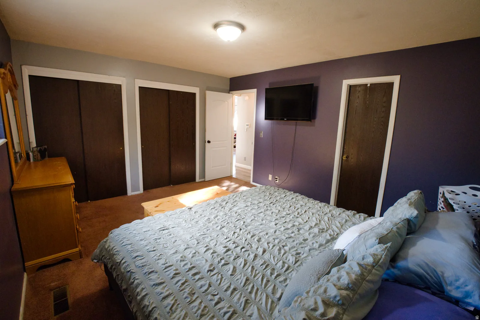 Recessed lighting, wood-finish bi-fold closet doors, and a paneled door with white trim