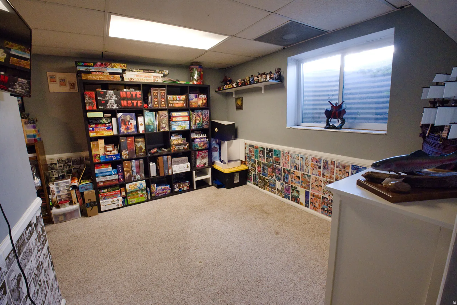 Finished room featuring carpet flooring, built-in shelving, and a window