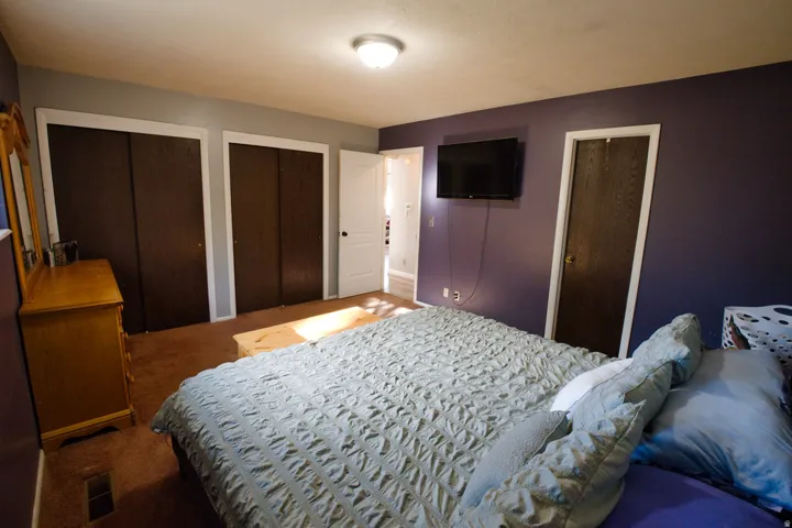 Recessed lighting, wood-finish bi-fold closet doors, and a paneled door with white trim