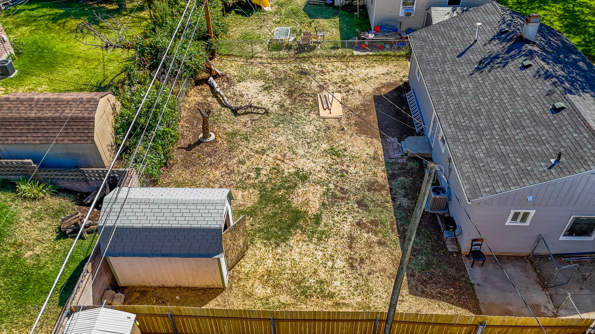 Fenced backyard featuring a gravel path and two storage sheds