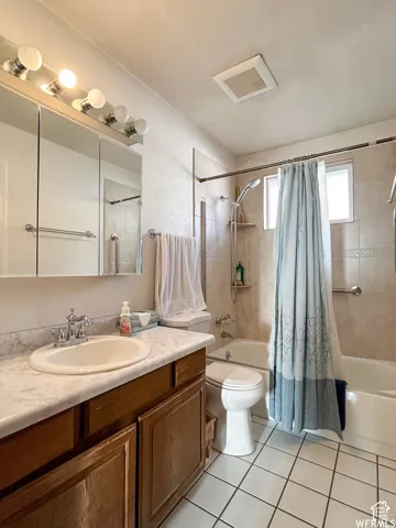 Bathroom featuring a vanity with a white countertop, an undermount sink, a chrome faucet, and a large mirror