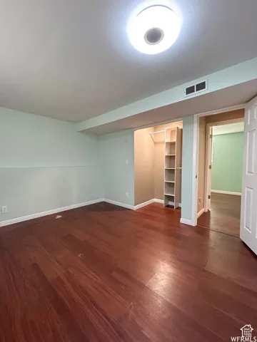 Rich wood-finish flooring, built-in closet shelving, and overhead lighting create a functional space