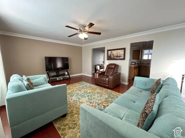 Recessed lighting, crown molding, wood-finish flooring, ceiling fan, and open doorway to kitchen