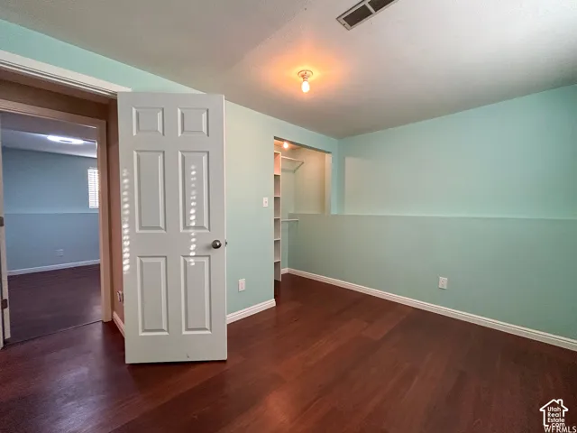 Wood-finish flooring throughout, light blue walls, built-in shelving, and a panel door