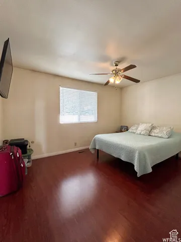 Wood-finish flooring throughout, ceiling fan with integrated lighting, and window with horizontal blinds