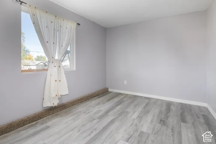 Light gray walls, wood-finish flooring, and white trim