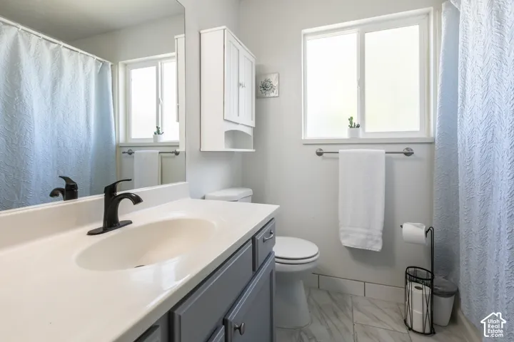 Vanity with integrated sink, matte black faucet, and gray cabinetry