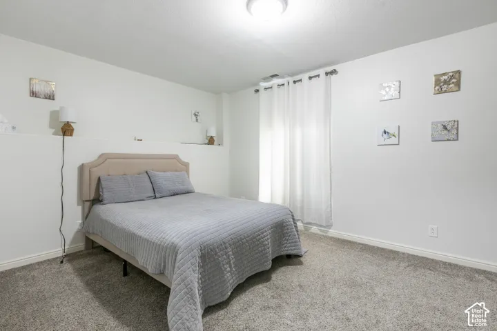 Wall-to-wall carpeting and white walls with a built-in shelf
