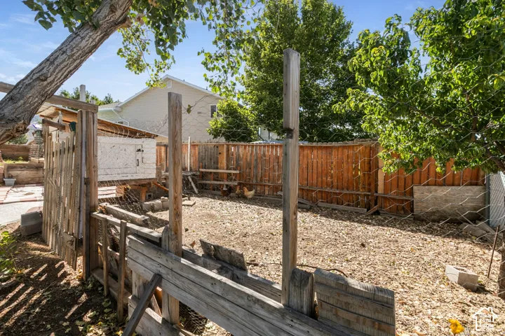 Enclosed yard area featuring a wooden fence and established trees