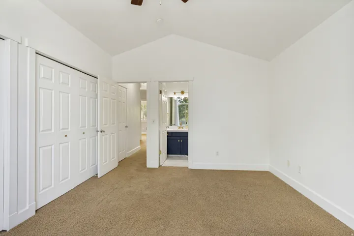 Vaulted ceiling, carpeted flooring, white walls, double bi-fold closet doors, and recessed lighting