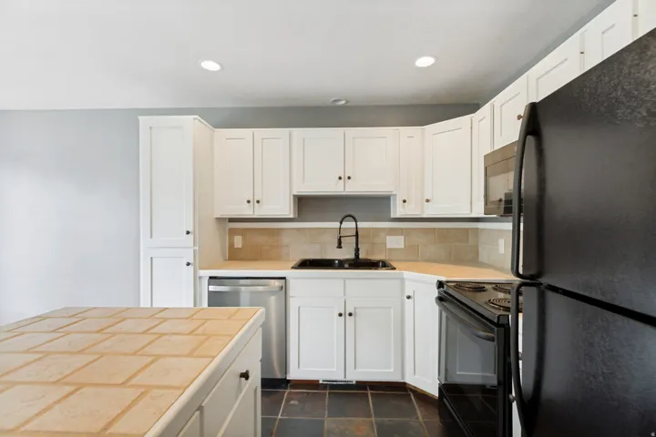 White cabinetry and black appliances