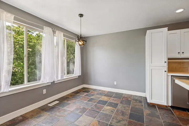 Full-height kitchen cabinetry, tile backsplash, and stainless steel appliances