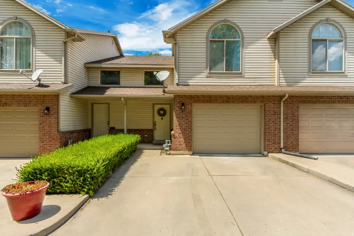 Exterior featuring brick and siding facade, arched windows, and an attached garage