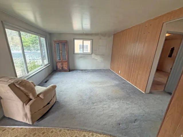 Expansive picture window, secondary window for natural light, and wood paneling accent wall