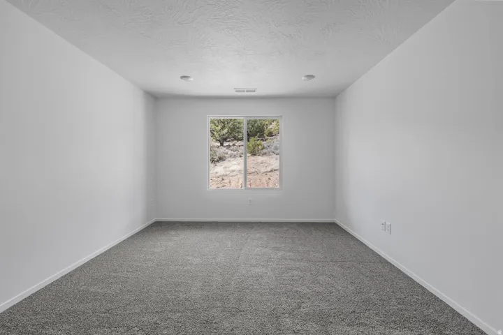 Recessed lighting, neutral color palette, grey carpet flooring, dual-pane window, power outlets