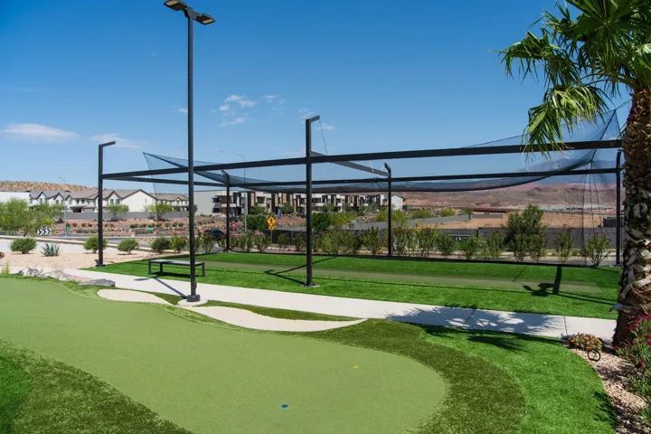 Putting green with artificial turf, bordered by a concrete pathway