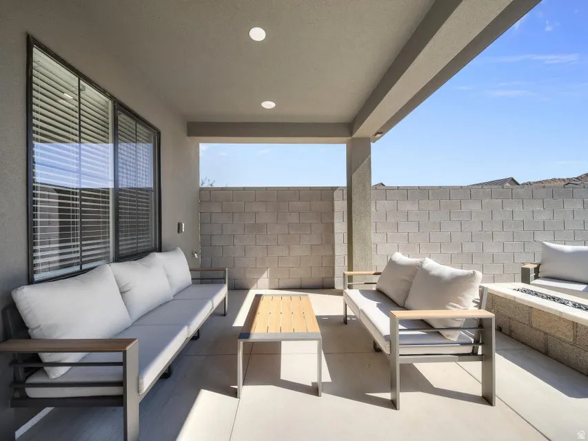 Covered patio featuring recessed lighting, a built-in fire pit, and a block wall surround