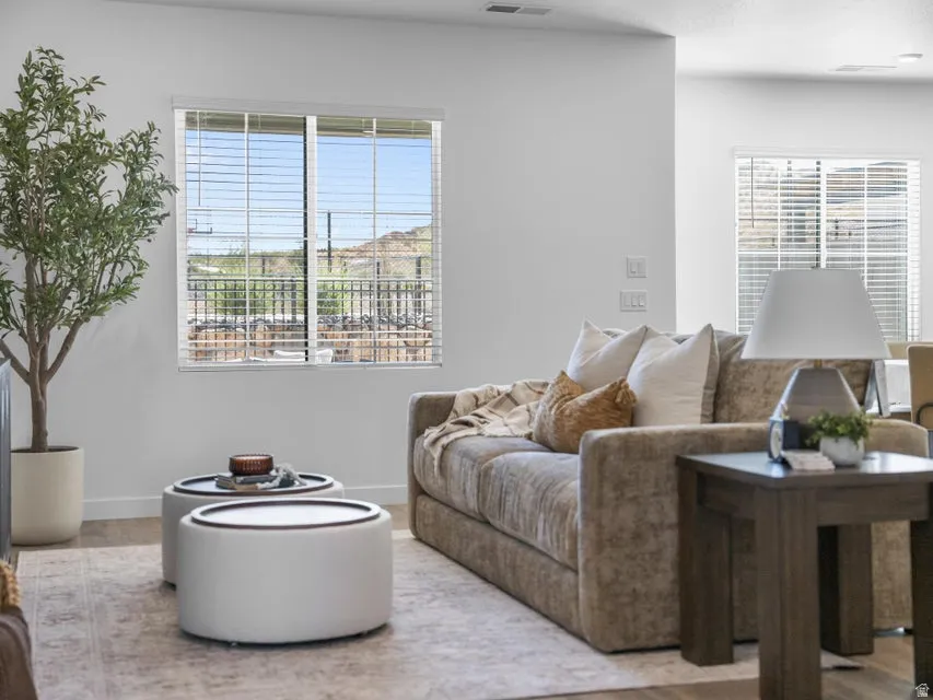 White walls, window with horizontal blinds, wood-finish flooring, and recessed lighting