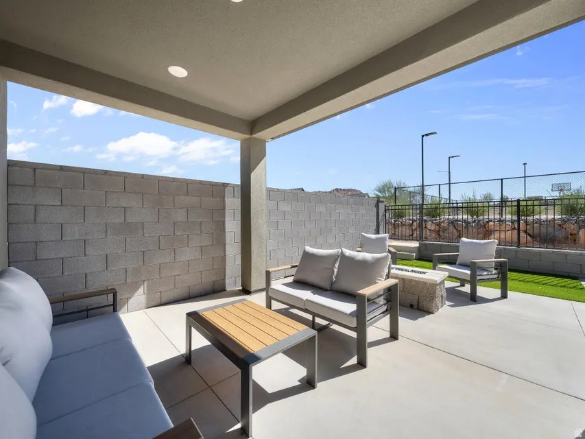 Expansive covered patio with recessed lighting, concrete flooring, and privacy block walls