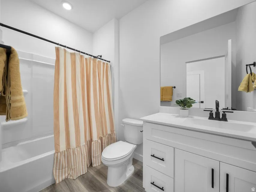 White vanity with black hardware, integrated sink, and wall-mounted mirror