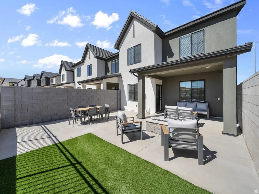 Private patio with concrete paver flooring, covered outdoor living space, and an artificial turf area