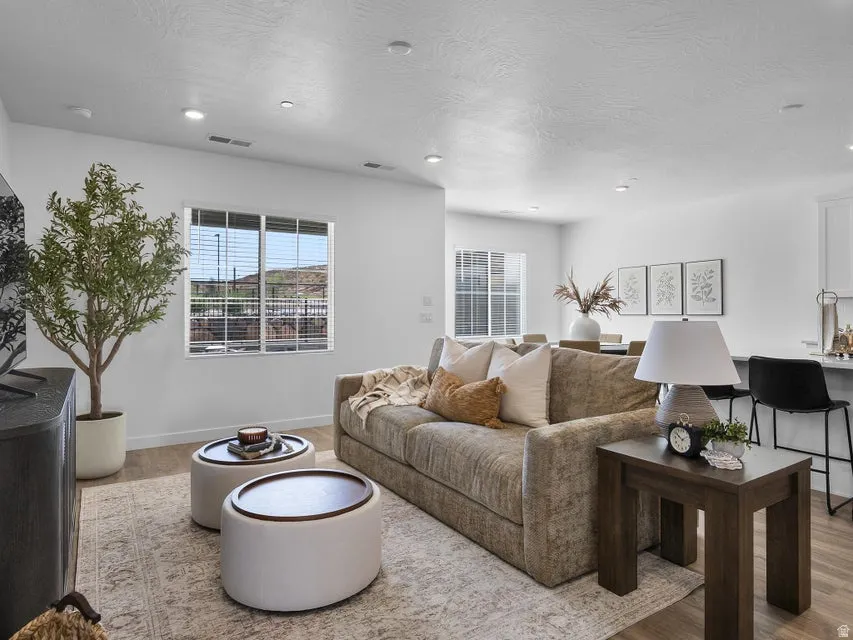 Recessed lighting, wood-finish flooring, and white walls