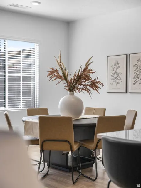 Recessed ceiling lighting, wood-finish flooring, and white window blinds