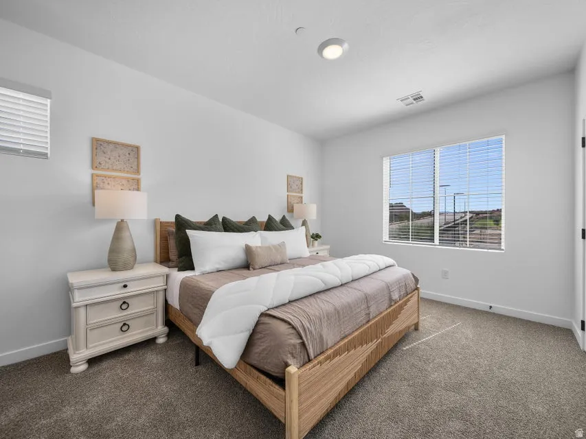 Recessed lighting, large window with blinds, carpeted flooring, and a white interior door with black hardware