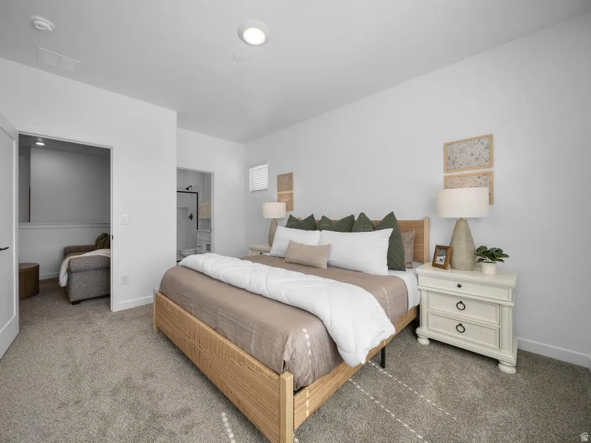 Carpeted bedroom featuring a recessed ceiling light, an open doorway, and a window with horizontal blinds