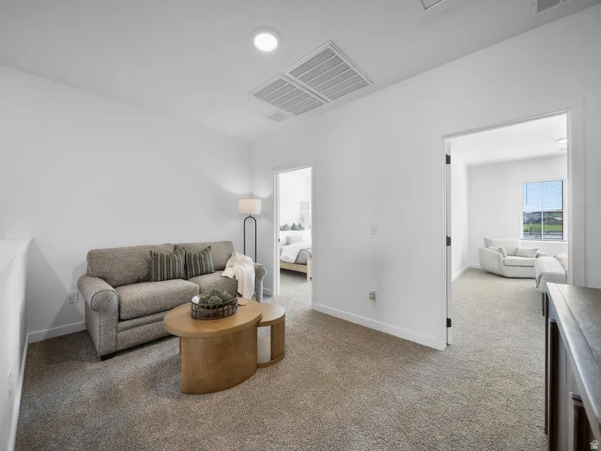 Carpeted floor throughout with flush-mounted ceiling lighting and a white wall finish