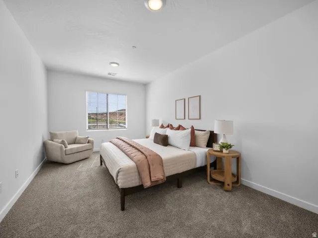 Recessed lighting illuminates the carpeted flooring and window with horizontal blinds