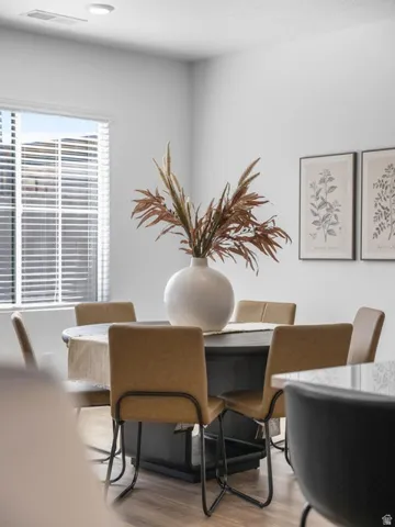 Recessed ceiling lighting, wood-finish flooring, and white window blinds
