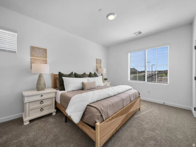 Recessed lighting, large window with blinds, carpeted flooring, and a white interior door with black hardware