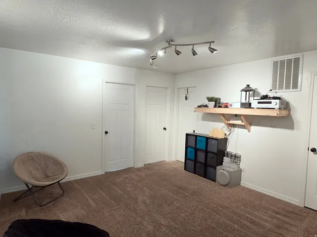 Recessed lighting, light-colored walls, and carpet flooring
