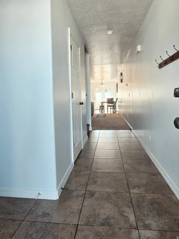 Tile flooring in the entryway with white trim and a paneled door