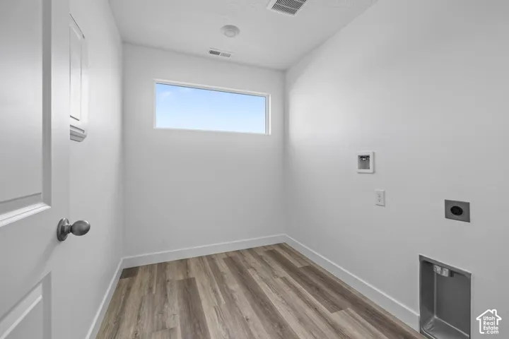 Wood-finish flooring, white walls, and a transom window provide natural light
