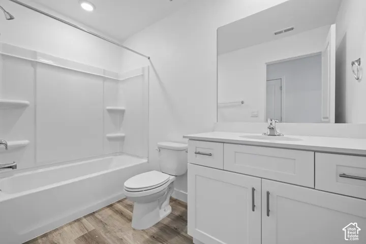 White vanity with shaker-style cabinetry, quartz countertop, and undermount sink