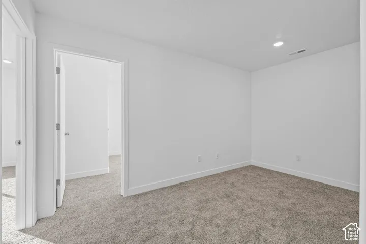 Neutral wall paint, recessed ceiling lighting, light-colored carpeting, white trim, and white doors