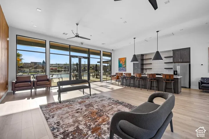 Open-concept space featuring wood-finish flooring, a full kitchen with stainless steel appliances, and large windows